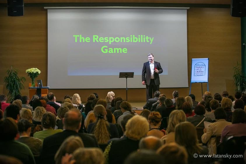 Mykola Latansky presenting on stage to a seated audience at a Neways event in Kyiv